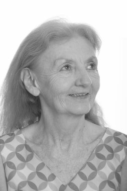 Siyah beyaz çekilen yaşlı bir kadının stüdyo portresi.