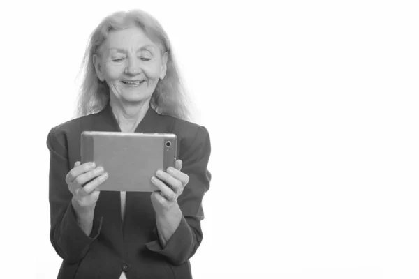 Mutlu kıdemli iş kadını dijital tablet kullanırken gülümsüyor — Stok fotoğraf