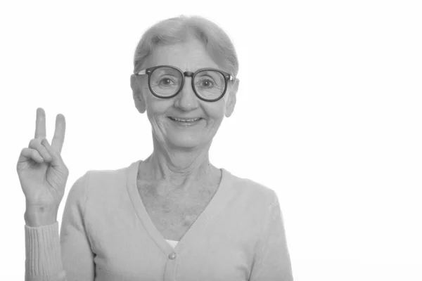 Heureuse femme nerd âgée souriante tout en donnant signe de paix et en portant des lunettes geek — Photo