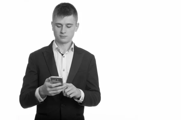 Студійний знімок молодого бізнесмена за допомогою мобільного телефону — стокове фото
