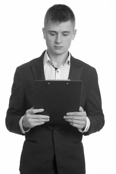 Studioaufnahme eines jungen Geschäftsmannes beim Lesen auf Klemmbrett — Stockfoto