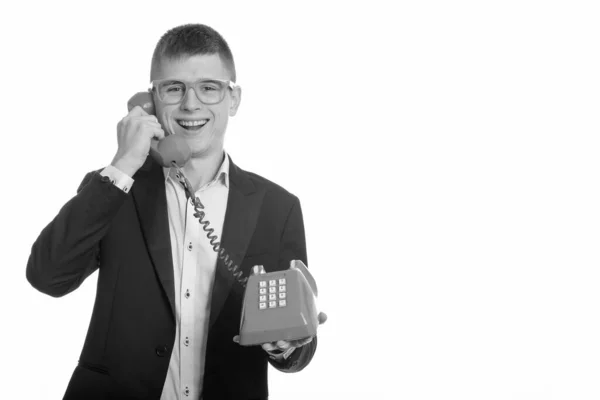 젊고 행복 한 사업가가 옛날 전화로 웃고 이야기하는 모습을 스튜디오에서 찍은 사진 — 스톡 사진