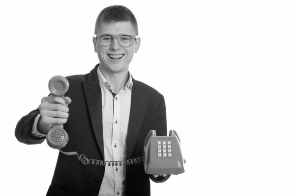 젊고 행복 한 사업가가 웃으며 오래 된 전화를 하는 스튜디오 촬영 — 스톡 사진