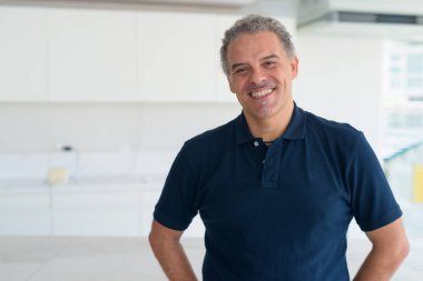 Mutlu olgun, yakışıklı İspanyol adam evde gülümsüyor.