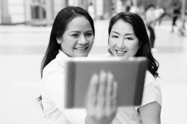 Dos mujeres asiáticas maduras juntas usando tableta digital — Foto de Stock