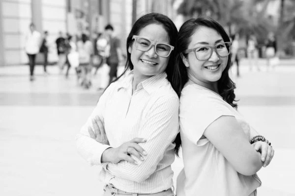 Dos mujeres asiáticas con anteojos al aire libre en blanco y negro — Foto de Stock