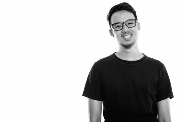 Estudio disparo de joven feliz asiático hombre sonriendo mientras llevaba gafas — Foto de Stock