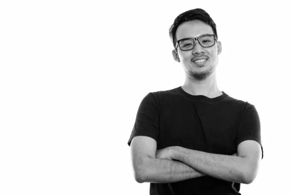 Studio ditembak pemuda Asia yang bahagia tersenyum sambil mengenakan kacamata dengan lengan disilangkan — Stok Foto