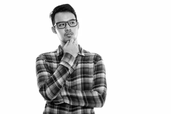 Estudio disparo de joven asiático hombre pensando mientras llevaba gafas —  Fotos de Stock