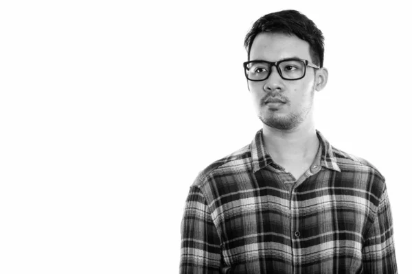 Photo prise en studio d'un jeune homme asiatique qui réfléchit et regarde à distance en portant des lunettes — Photo