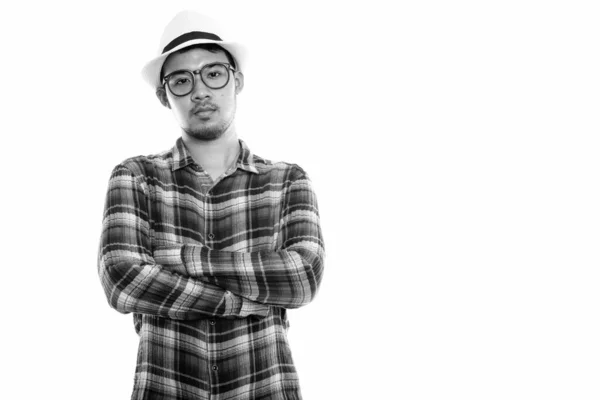 Studio skott av ung asiatisk man med armarna korsade — Stockfoto