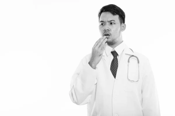 Студийный снимок молодого азиатского врача, выглядящего шокированным — стоковое фото