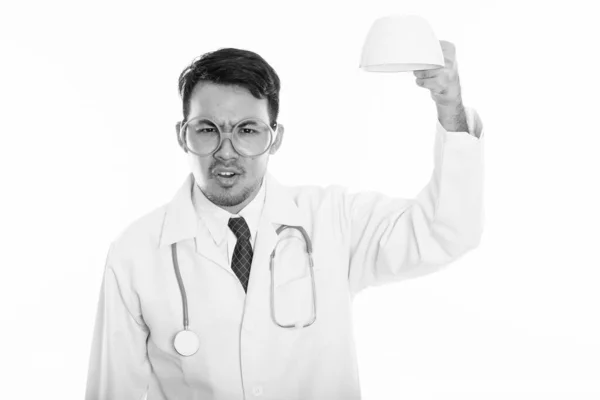 Studio shot of young angry Asian man doctor holding empty coffee cup upside down — Stock Photo, Image