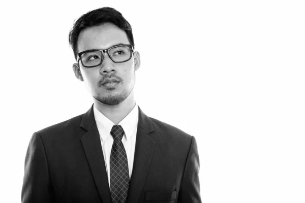 Stüdyo çekim gözlük düşünürken giyen genç Asya iş adamı — Stok fotoğraf