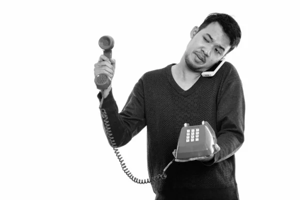 Στιγμιότυπο του νεαρού Ασιάτη να δίνει παλιό τηλέφωνο ενώ μιλάει στο κινητό — Φωτογραφία Αρχείου