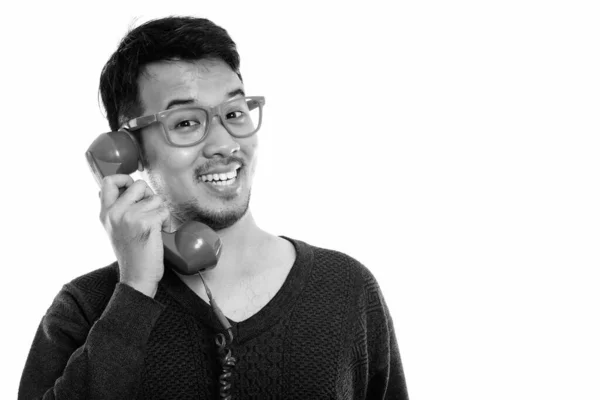 Primer plano de joven feliz asiático hombre sonriendo mientras habla por teléfono viejo — Foto de Stock