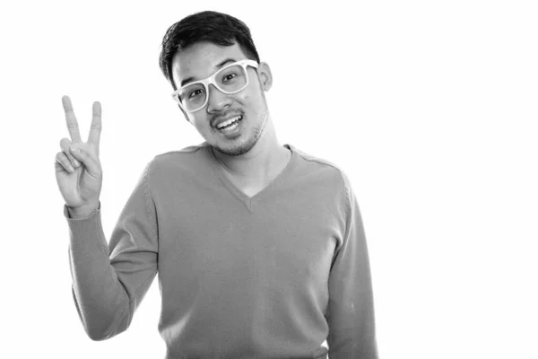 Estudio disparo de joven feliz asiático hombre sonriendo y dando señal de paz — Foto de Stock