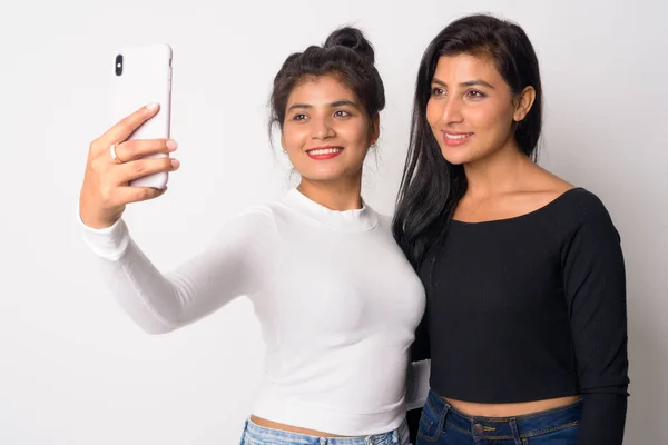 Dos jóvenes felices hermosas mujeres persas tomando selfie juntas —  Fotos de Stock