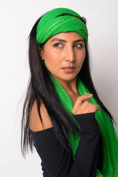 Face of young beautiful Persian woman with head scarf thinking