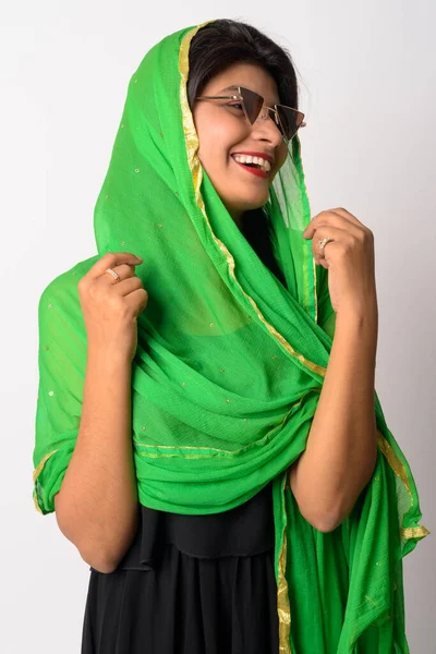 Happy young Persian woman with sunglasses laughing in traditional clothing