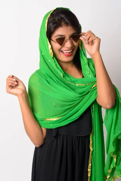 Happy young Persian woman with sunglasses smiling in traditional clothing