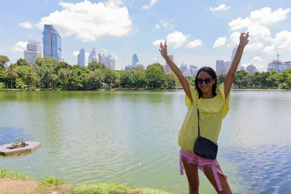 Tourist woman with arms raised at Lumpini Park in Bangkok Thailand — Stock Photo, Image