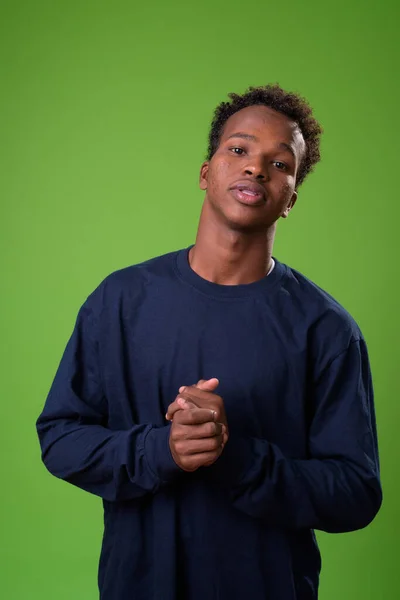 Junger afrikanischer Mann vor grünem Hintergrund — Stockfoto
