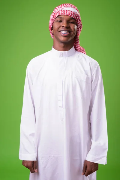 Молодой африканский мужчина в традиционной мусульманской одежде против гра — стоковое фото