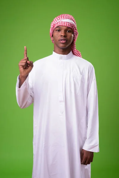 Jeune homme africain portant des vêtements musulmans traditionnels contre le gre — Photo