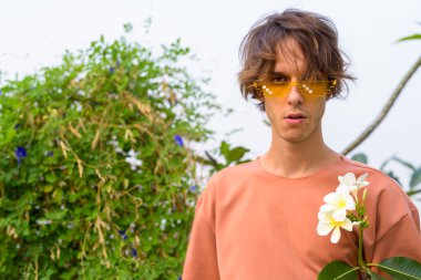 Dışarıda gözlüklü yakışıklı asi bir adam var.