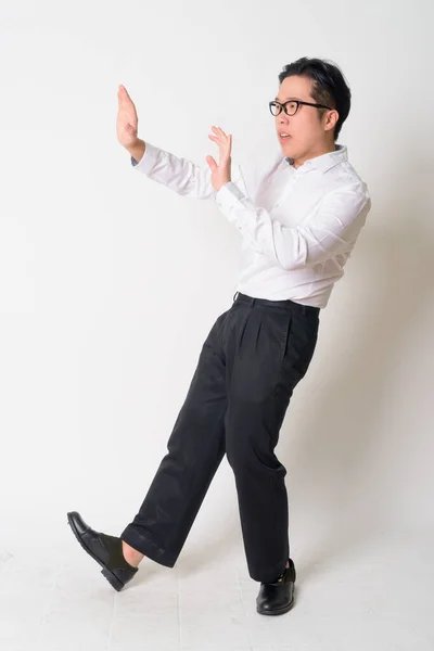 Portret zestresowanego młodego azjatyckiego biznesmena w okularach uciekającego — Zdjęcie stockowe