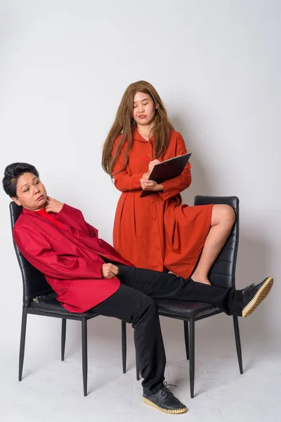 Mature Asian businesswoman and weird Asian woman therapist having consultation together