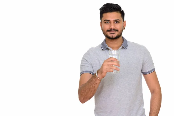 Young handsome Indian man holding glass of water — Stock Photo, Image