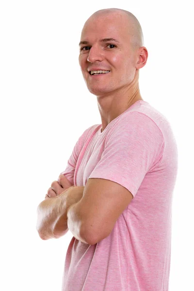 Studio shot of young happy bald man smiling with arms crossed — Stock Photo, Image