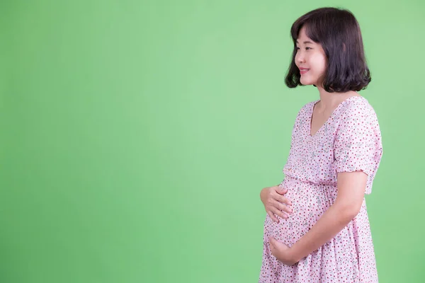 Profiel weergave van gelukkig aziatische zwangere vrouw glimlachen — Stockfoto