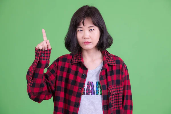 Porträtt av vacker asiatisk hipster kvinna pekar uppåt — Stockfoto