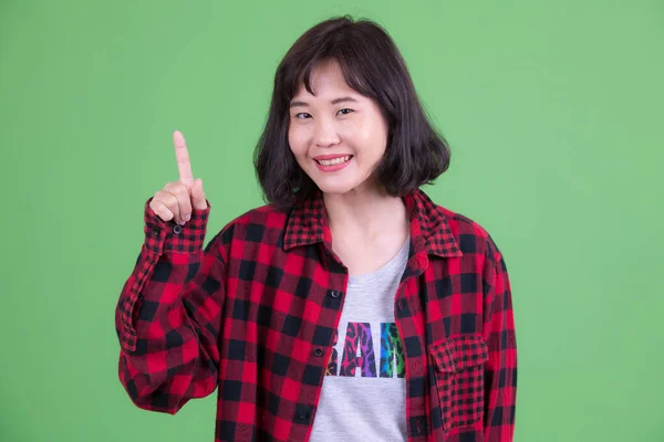 Retrato de mujer hipster asiática feliz señalando hacia arriba —  Fotos de Stock
