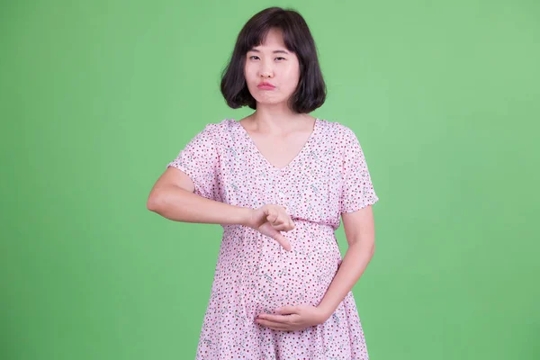 Retrato de mulher grávida asiática estressada dando polegares para baixo — Fotografia de Stock