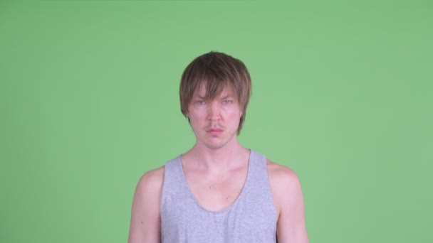 Обличчя молодого чоловіка з брудним волоссям виглядає шокованим — стокове відео