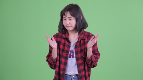 Hermosa mujer hipster asiático encogiéndose de hombros y buscando culpable — Vídeo de stock