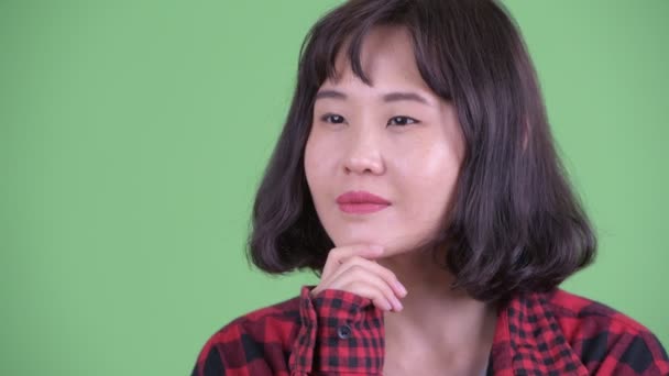 Twarz szczęśliwej azjatyckiej hipsterki myślącej i patrzącej w górę — Wideo stockowe
