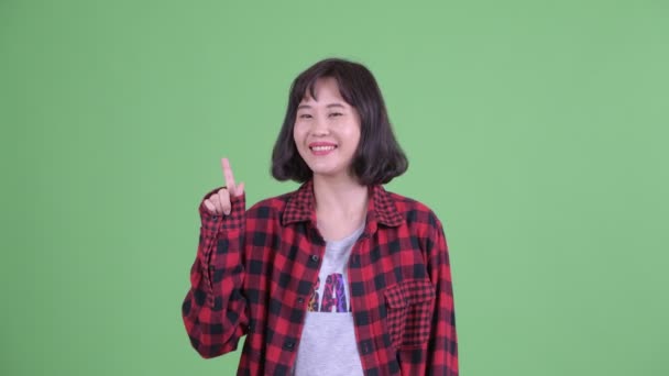 Щаслива азіатська гіпстерка, що вказує вгору. — стокове відео