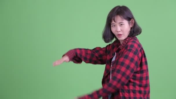 Šťastný asijské hipster žena luskání prsty a ukazující něco — Stock video