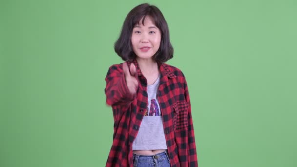 Щаслива жінка азіатського хіпстера, що вказує на камеру. — стокове відео