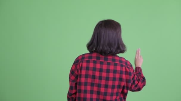 Vista trasera de mujer hipster asiática tocando algo — Vídeos de Stock