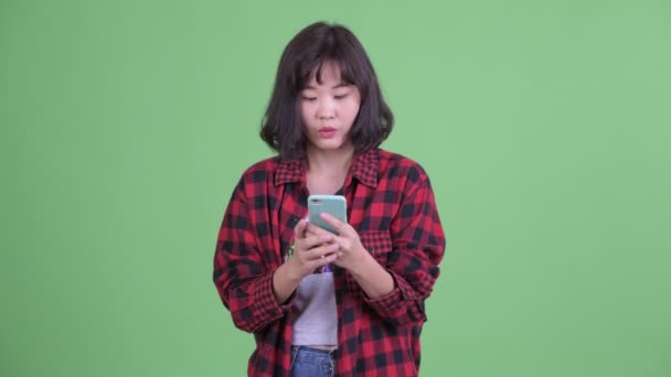 Mutlu Asyalı hippi kadın telefonu kullanıyor ve iyi haberler alıyor. — Stok video