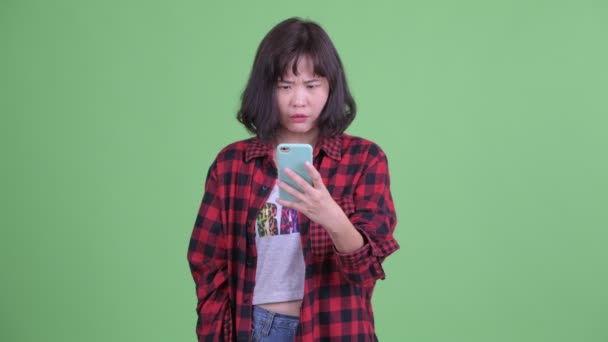 Gestrest aziatische hipster vrouw met behulp van telefoon en het krijgen van slecht nieuws — Stockvideo