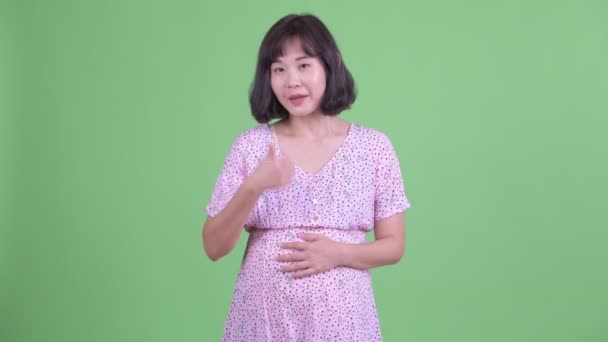 Feliz asiático embarazada mujer dando pulgares arriba — Vídeo de stock