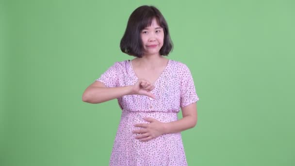 Stressad asiatisk gravid kvinna som ger tummar ner — Stockvideo