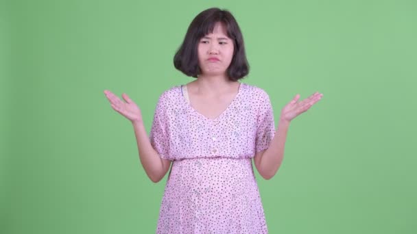 Confused Asian pregnant woman shrugging shoulders — Stock Video